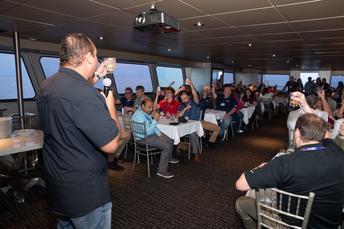 Man leads toast with room of people